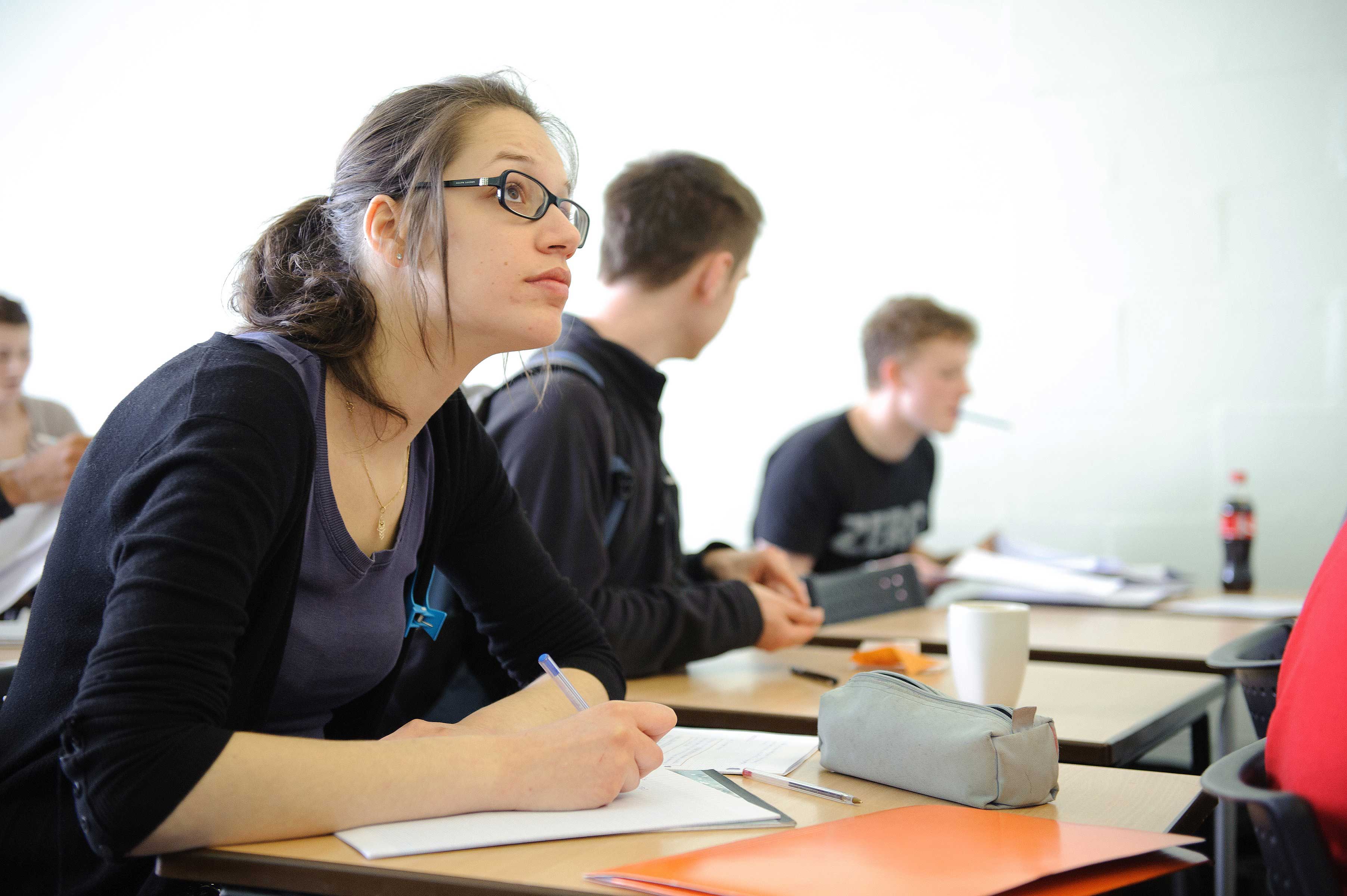 Maths student at desk looking upwards