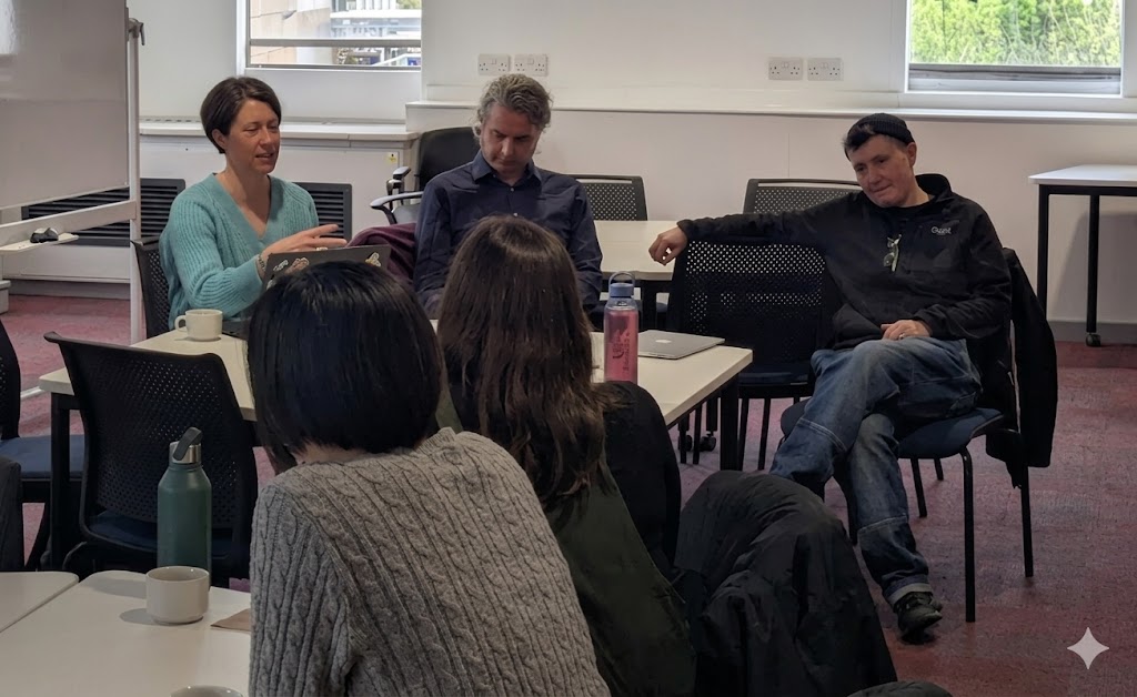 Artists sitting at a table and talking to attendees