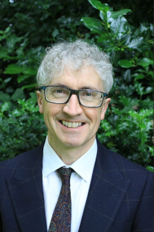 Professor Piran White, standing infront of a green hedge