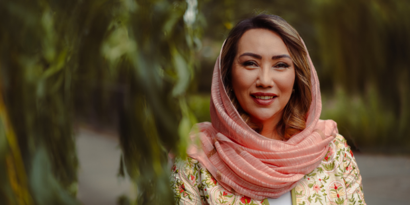 Fawzia is smiling outside on campus