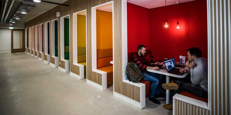 Two students sitting in a booth style study space at Maastricht University.