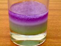 Picture of step 7, a white string-like layer of DNA is visible in the glass between the green and purple layers.